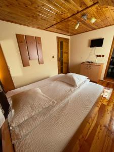 阿列谢尼Cabana Med 2的一间卧室设有一张带木制天花板的大床