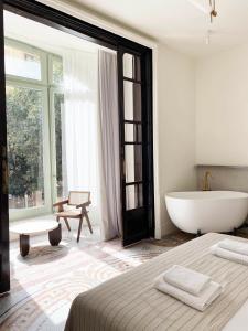 巴塞罗那Casa Llimona Hotel Boutique的白色的浴室设有浴缸、床和浴缸。