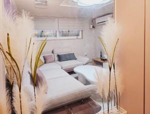 首尔Close to Gangnam, COEX & Luxury Apartment near Lotte world的客厅配有2张白色沙发和植物