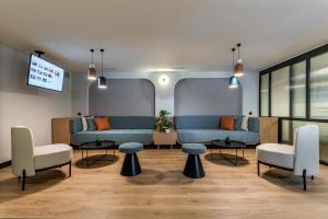塞萨洛尼基Thirtynine Urban Stay的一间设有两张蓝色沙发和椅子的等候室
