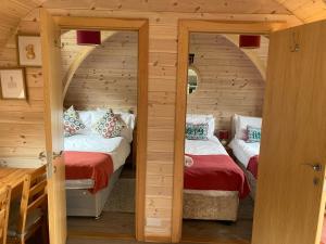 LeightonSquirrel Glamping Pod School House Farm的小木屋内一间卧室,配有两张床