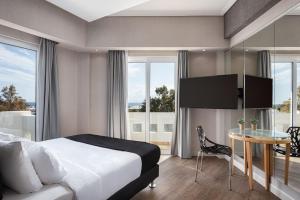 雅典Kreoli Suites Glyfada的酒店客房设有床、桌子和窗户。