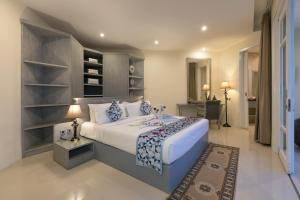 勒吉安Awila Villas Kuta的卧室配有一张白色的大床和一张桌子