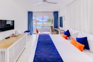 亭可马里西纳蒙特林克布鲁酒店的一间卧室配有一张带蓝色和橙色枕头的大床