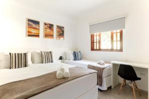 帕拉蒂瑞坎托亚巴卡拉宾馆的一间白色卧室,配有两张床和一张书桌