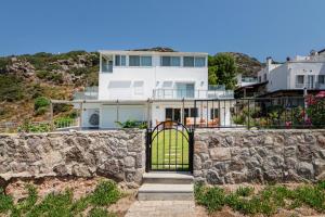 亚力卡瓦克Villa w Pool Garden Patio 1 min to Beach in Bodrum的白色的房子,有石墙和门