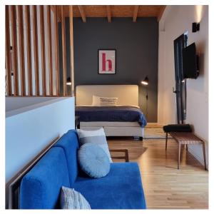 马格德堡ElbQuartier Apartments Magdeburg 'Fabrik61'的客厅配有蓝色的沙发和床。