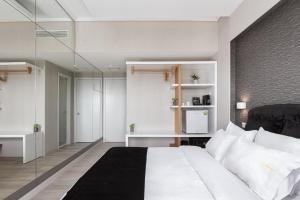 雅典Kreoli Suites Glyfada的卧室配有白色的床和玻璃墙