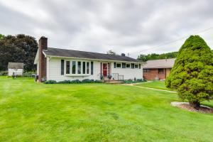 EmlentonPennsylvania Countryside Retreat with Deck and Yard!的一间白色的房子,有红色的门和一个院子