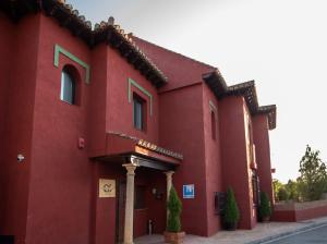塞内斯德拉韦加Hotel Boutique Cerro del Sol的一面有标志的红色建筑
