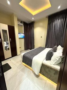 伊凯贾GOD'S TOUCH APARTMENTS SHORT-LET Adenugba Street Oregun Ikeja Lagos Nigeria的一间卧室设有一张大床和一个大窗户