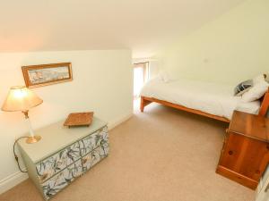 新港Garstons Barn的一间卧室配有一张床和一张带台灯的桌子