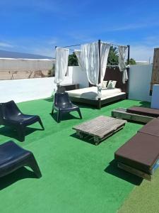 厄尔梅达诺La casita de Aitor; campo y playa en el Médano的一间屋顶上配有绿色地毯和椅子的房间