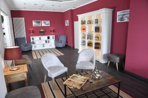 格洛米茨Carat Apartments Grömitz的客厅设有红色的墙壁和桌椅