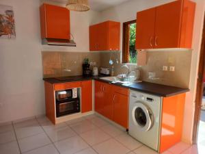 珀蒂堡Bungalow Abricot的厨房配有橙色橱柜和洗衣机。
