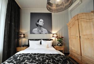 杜塞尔多夫第47舞台酒店的卧室,配有一张床和一张女人的肖像