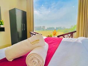 齐拉克普尔Stay @Northview park hotel zirakpur的酒店客房,配有一张带毛巾的床和窗户