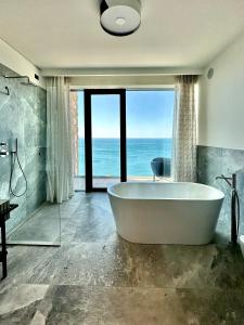 的里雅斯特Maximilian Suites的带浴缸的浴室,享有海景。