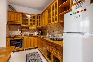 地拉那Hostel Nena Semi的厨房配有木制橱柜和白色冰箱。