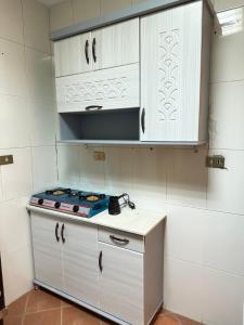 开罗Great room downtown的厨房配有炉灶和白色橱柜。