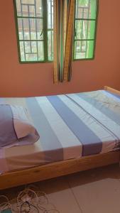 基加利Hostelito Room的配有2扇窗户的客房内的1张床