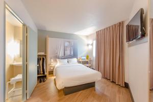 维讷伊B&B HOTEL Blois的配有一张床和一张书桌的酒店客房