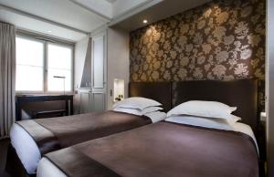 巴黎杜尔酒店的配有花卉壁纸的两张床的客房
