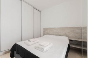 布宜诺斯艾利斯Lumimoso departamento en Buenos Aires 1 dorm的一间卧室配有一张床,上面有两条毛巾