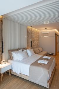 佩基罗德THERETRA PEFKI Seaside的卧室配有一张白色的大床和一张沙发。