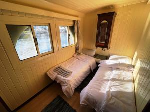 卢克索Floating Hotel- Happy Nile Boat的带2扇窗户的客房内的2张床