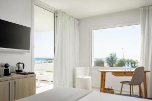 圣苏珊娜ALEGRIA Mar Mediterrania - Adults Only 4*Sup的一间卧室配有一张床、一张桌子和一张桌子及一台电视