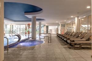 圣苏珊娜ALEGRIA Caprici Verd的酒店大堂设有游泳池和椅子