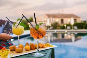 卡塔尼亚Nèroli Bio Relais的池畔餐桌上的两杯饮料