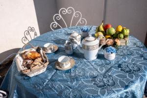 卡尔塔尼塞塔Un posto al sole - Caltanissetta的一张蓝色桌子,上面有一篮子食物和水果
