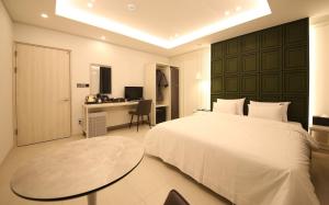 光州Brown Dot Hotel Sinan的一间卧室配有一张床、一张桌子和一张桌子