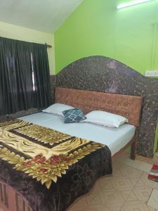科尔瓦Colva Beach Samaira GuestHouse & Apartments的一张带木制床头板和白色枕头的床