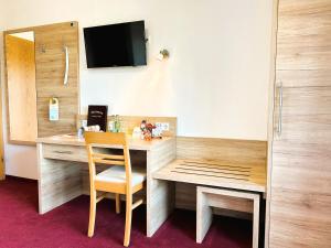 Eresing韦德曼乡村酒店的客房设有一张桌子、一把椅子和一台电视