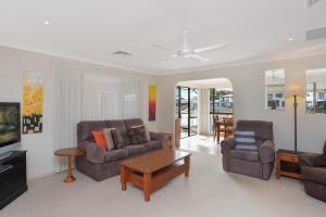 麦夸里港Hibbard 12的客厅配有两张沙发和一台电视机
