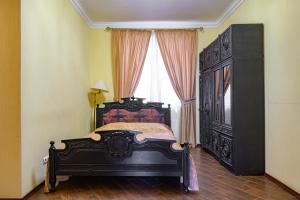 敖德萨戈斯廷尼德沃尔酒店的一间卧室设有一张黑色的床和一个窗户。