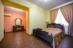 敖德萨戈斯廷尼德沃尔酒店的一间卧室配有一张床、梳妆台和镜子