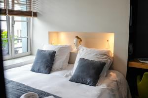 索姆河畔的圣瓦列里Maison d'hôtes du Jardin的一间卧室配有白色床和蓝色枕头