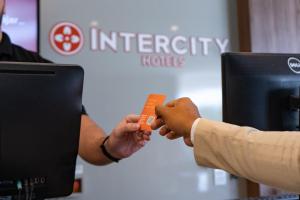 蒙蒂斯克拉鲁斯蒙特斯克拉罗斯城际酒店的两个人正在交换橙色信用卡