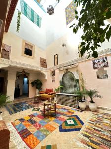 非斯Dar Khmissa Fes的一间客厅,地板上铺着色彩缤纷的地毯