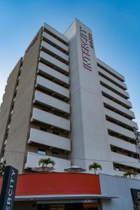 蒙蒂斯克拉鲁斯蒙特斯克拉罗斯城际酒店的一座高大的建筑,前面有棕榈树