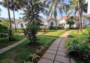 阿伯来Riviera Hermitage Goa的棕榈树屋前的走道
