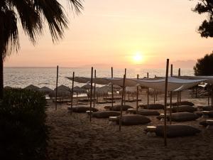 瓦西里科斯海湾套房酒店的沙滩上和大海上都有遮阳伞