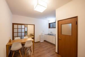 日光苏米卡公寓的厨房以及带木桌和椅子的用餐室。