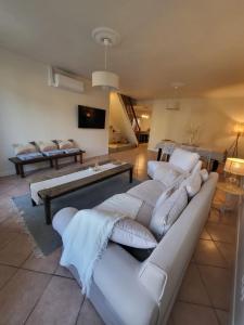 RadonvilliersL'OREE DES LACS, Maison de village tout confort的客厅配有白色沙发和电视