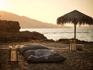 瓦西里科斯海湾套房酒店的海滩上的帐篷和遮阳伞
