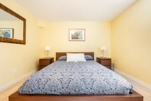 班夫Cougar Street Mountain Rental的一间卧室配有床和2个床头柜